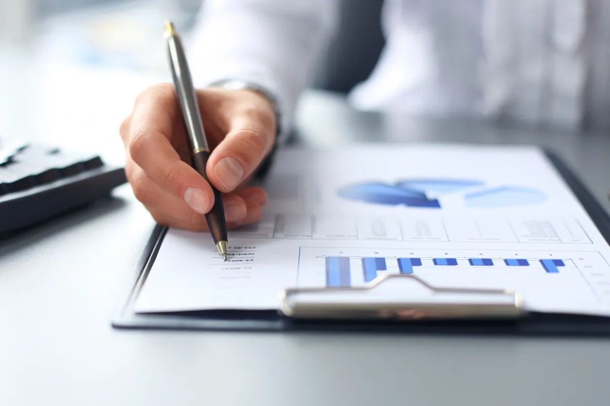 Person analyzing financial data on clipboard